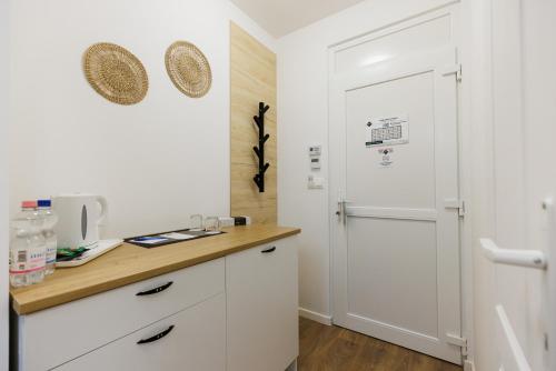 a kitchen with white cabinets and a door at Safari Hotel in Szeged