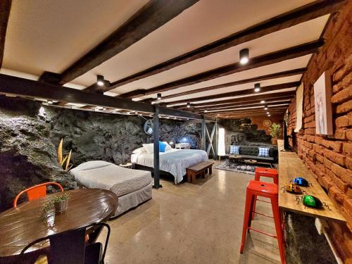 Maki Hostels & Suites Valparaiso في فالبارايسو: غرفة نوم بسريرين وجدار من الطوب