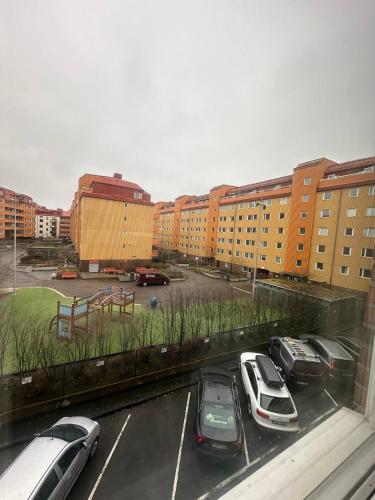 un aparcamiento con coches estacionados frente a los edificios en Beautiful And Comfortable Apartment en Gotemburgo