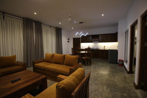 a living room with a couch and a table at Hotel Refresh Blue in Hikkaduwa