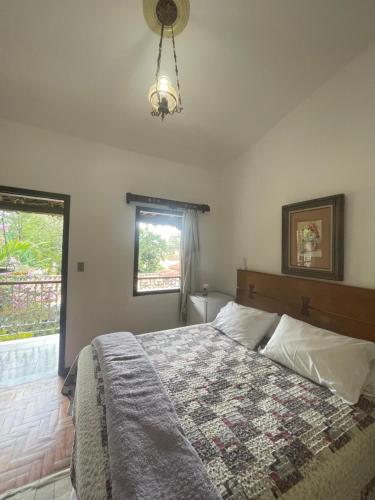 1 dormitorio con cama y ventana en Pousada das Artes, en Tiradentes
