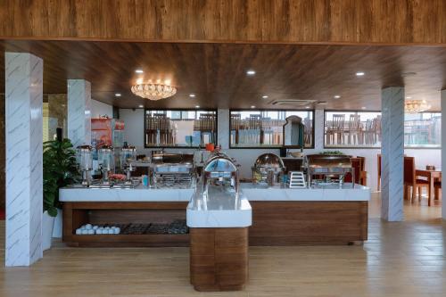 un restaurante con barra y cocina. en Maya Hotel 4, en Con Dao