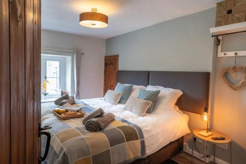 a bedroom with a bed with a tray of food on it at Cosy Matlock Cottage with Fireplace, Stunning Views & Pet Friendly in Two Dales
