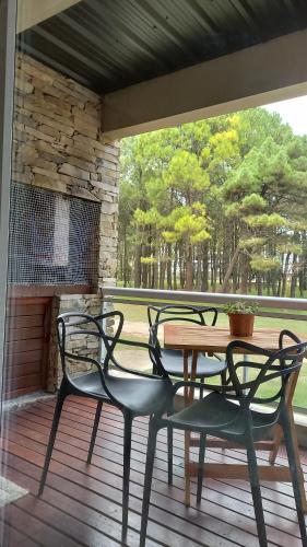 una mesa y 2 sillas en un porche con mesa y sillas en Natureza en Pinamar