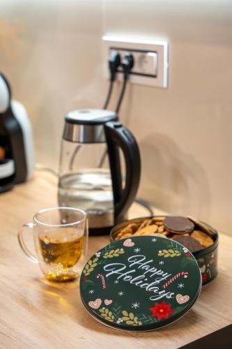 a coffee pot and a plate and a glass on a table at SkyLine Lux 2 Apartman Zlatibor in Zlatibor