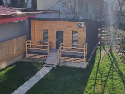 un pequeño edificio con dos bancos en un patio en La Casuță en Dej