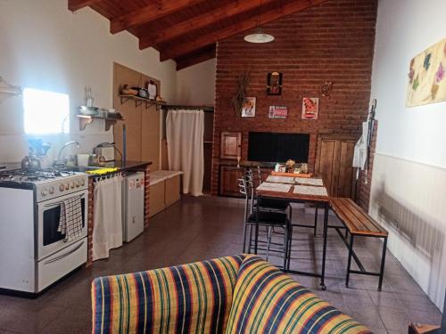 cocina con fogones y mesa con sofá en Rincón Mágico en Trelew