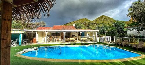 a large swimming pool in front of a house at La Rose du Bresil Marie-Galante in Capesterre-de-Marie-Galante