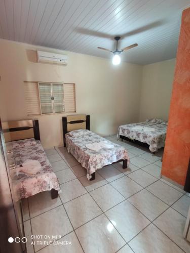 a room with two beds and a ceiling at Hotel Pousada Bela Manhã in Pôrto Primavera