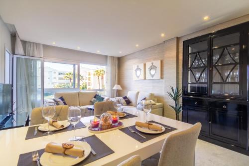 a dining room and living room with a table and chairs at MARBELLA BANUS SUITES - Banus Playa Rocio Direct Sea Access in Marbella