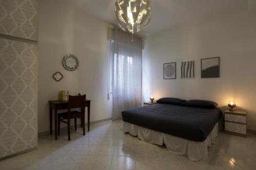 a bedroom with a bed and a table and a chandelier at Casa dell'Opera in Pesaro