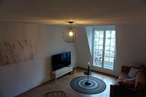 uma sala de estar com um sofá e uma televisão em Stadt nah, Modern, bequem, em Thun