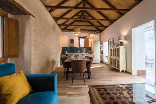 ein Wohnzimmer mit einem Esstisch und einer Küche in der Unterkunft Preciosa Casa Renovada Centro Histórico 11 personas in Sevilla