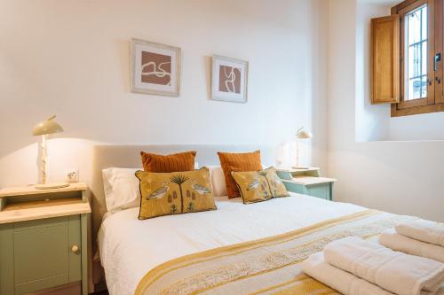 um quarto com uma cama com almofadas em Preciosa Casa Renovada Centro Histórico 11 personas em Sevilha