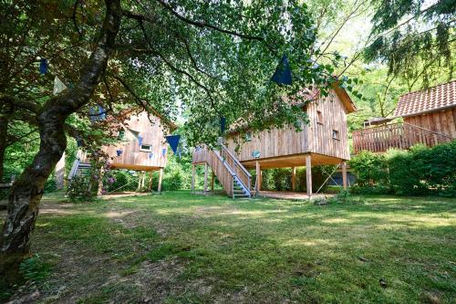 a large wooden house with a staircase in a yard at Baumschiffhotel am Waldbad in Bad Rodach