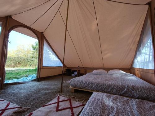 a bedroom with a tent with two beds and windows at Du cote de Roussay in Roussay