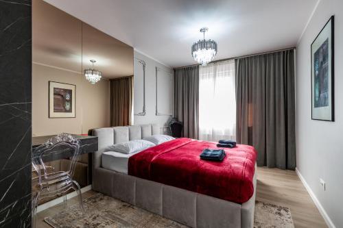 a bedroom with a large bed with a red blanket at STUDIO 92- URBAN PLAZA in Braşov