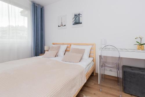 a small bedroom with a bed and a desk at Bright Apartment with Private Garden and Accepting Pets by Noclegi Renters in Gdańsk