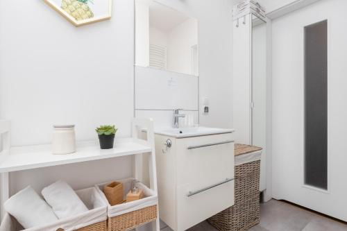 a white bathroom with a sink and a mirror at Bright Apartment with Private Garden and Accepting Pets by Noclegi Renters in Gdańsk