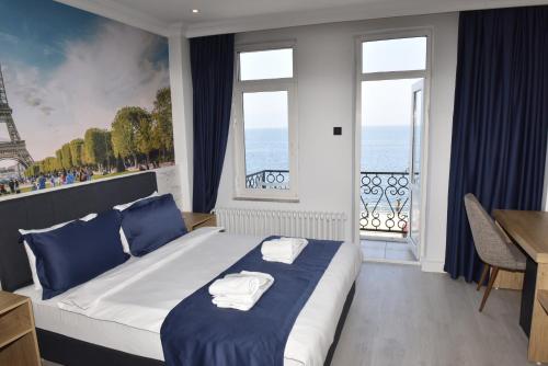 a bedroom with a bed and a balcony with the eiffel tower at Bella Otel Mudanya in Mudanya