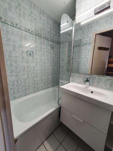 La salle de bains est pourvue d'une baignoire blanche, d'un lavabo et d'une baignoire. dans l'établissement Meije 15 - K3 - Studio vue degagee - 4 pers, à Les Deux Alpes