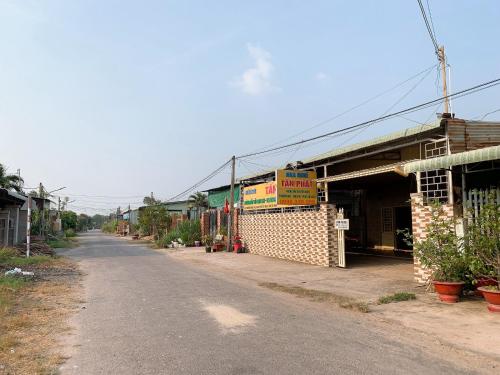 una strada vuota in un villaggio con un edificio di Nhà Nghỉ Tấn Phát a Ấp Thanh Sơn (1)