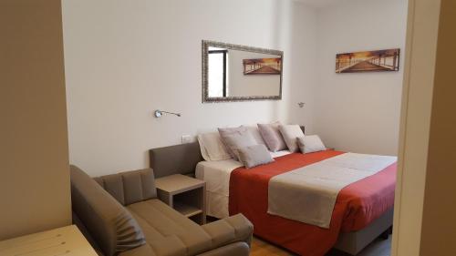 a bedroom with a bed and a chair and a mirror at Hotel Pace in Brenzone sul Garda