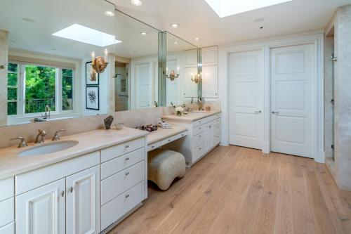 uma casa de banho com 2 lavatórios e um espelho grande em Lavish Montecito Home with Hot Tub, Patio and Gardens! em Montecito