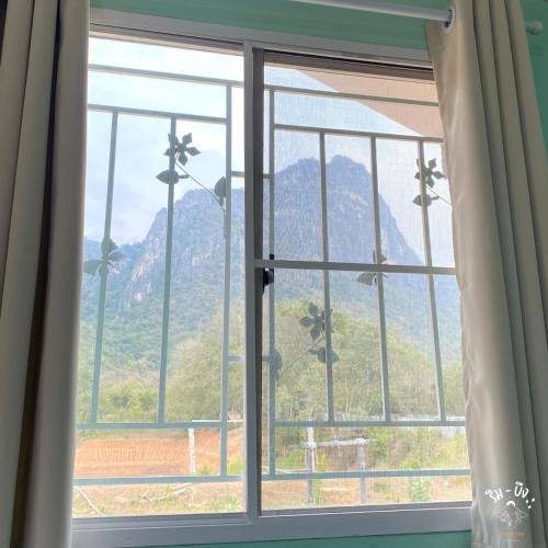 a window with a view of a mountain at ริมบึงโฮมสเตย์ in Ban Phu Noi
