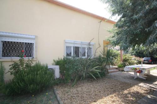 uma casa com um banco e plantas em frente em An iodized vacation at home! em Frontignan