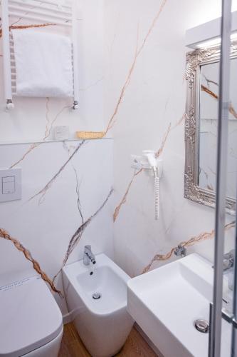 a bathroom with a sink and a toilet and a mirror at Hotel Centrale in Bologna