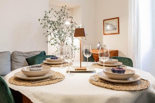 una mesa con platos y copas de vino. en H11 [The King's Apartment] Ariston - Centro, en San Remo