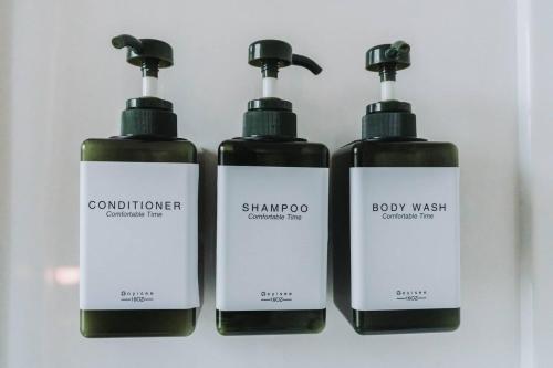 three bottles of shampoo and body wash on a shelf at Manoir Des Curiosits in La Pérade