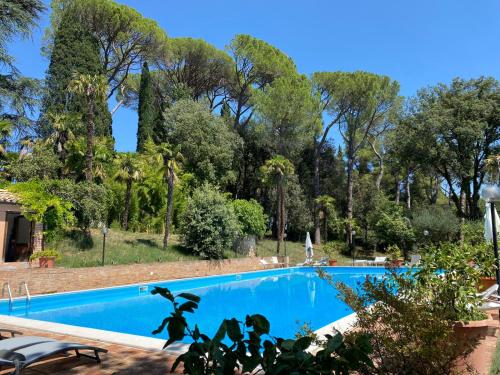 a large blue swimming pool with trees in the background at camere in Villa Luzi in Treia