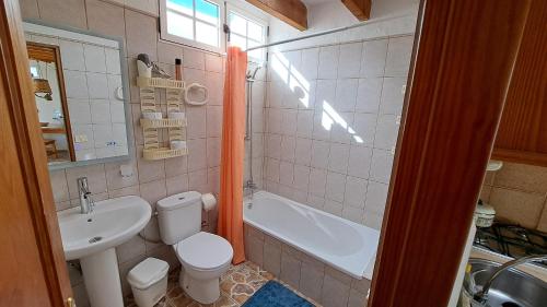 a bathroom with a sink and a toilet and a bath tub at Inviting 1-bed house 'Esquina' Finca Vistamar in Salobre