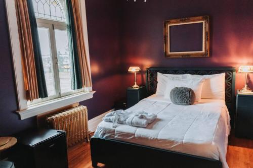 a bedroom with a bed with two towels on it at Manoir Des Curiosits in La Pérade