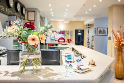 a vase of flowers on a counter in a store at Hotel Centrale in Bologna