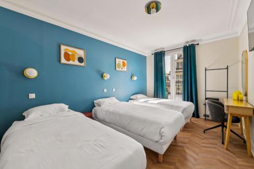 three beds in a room with blue walls at Hotel Margot in Paris