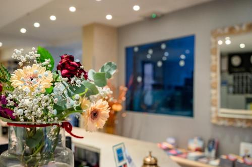 a vase filled with flowers on top of a counter at Hotel Centrale in Bologna