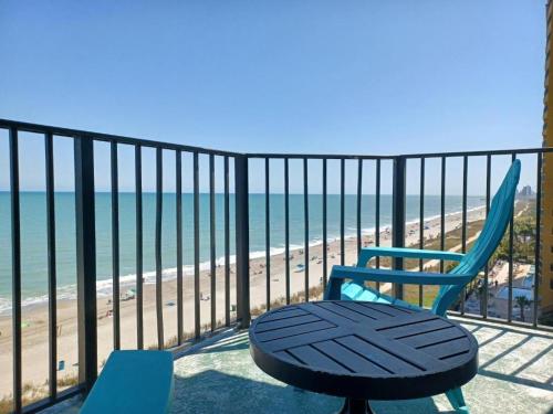 une chaise bleue assise sur un balcon donnant sur la plage dans l'établissement Blue Palmetto, à Myrtle Beach