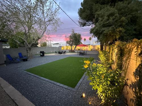 a garden with a green lawn next to a wall at Cheerful PHX Home and Guest House in Central PHX in Phoenix