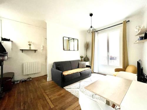 un salon avec un canapé et une table dans l'établissement Appartement 2 pièces - 1 chambre, à Asnières-sur-Seine