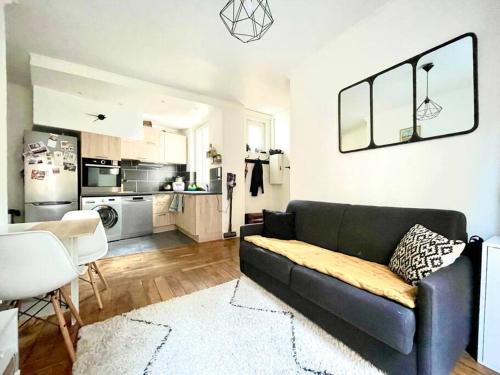 un salon avec un canapé et une cuisine dans l'établissement Appartement 2 pièces - 1 chambre, à Asnières-sur-Seine