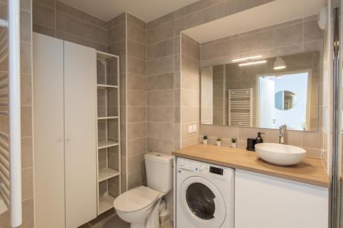 une salle de bain avec une machine à laver et un lavabo dans l'établissement A5 - Modern Studio 5 min to Sea - Pool & Garage, à Antibes