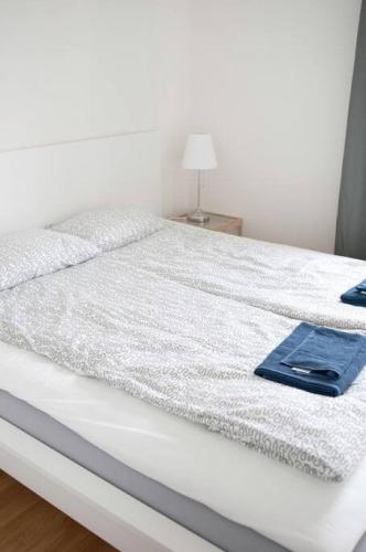 a white bed with a blue towel on it at Lovely 1 bedroom flat in Larsberg, Lidingo in Kottla