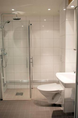 uma casa de banho com um chuveiro, um WC e um lavatório. em Lovely 1 bedroom flat in Larsberg, Lidingo em Kottla