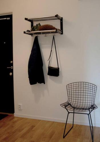uma cadeira num quarto ao lado de uma parede com uma prateleira em Lovely 1 bedroom flat in Larsberg, Lidingo em Kottla