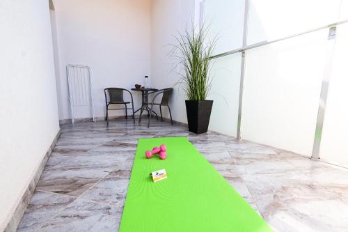 a green floor with a pair of pink shoes on it at RUBO Hotel in Shumen