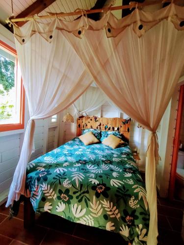 a bedroom with a bed with a canopy at Kaz à Rosa in Petit-Bourg