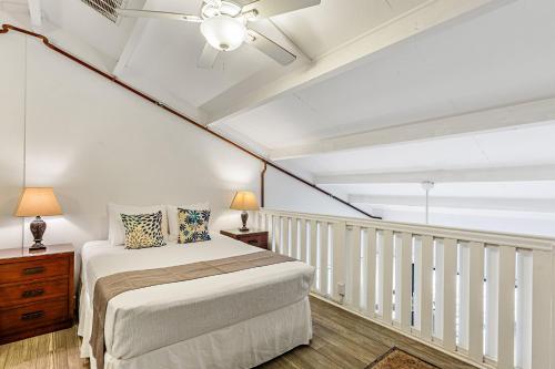 a bedroom with a bed and a balcony at Polynesian Shores 205 in Kahana